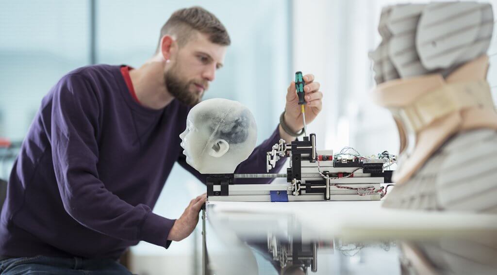 Member of research team adjusting mask and headgear testing rig